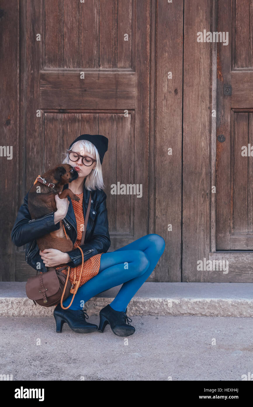 Young woman holding dog outdoors Stock Photo