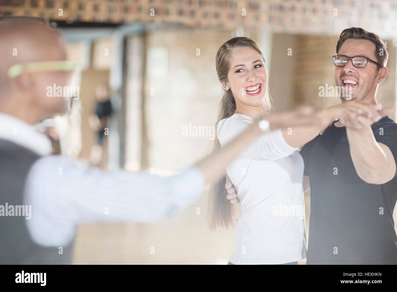 Smiling dance partners together in dance class with instructor Stock