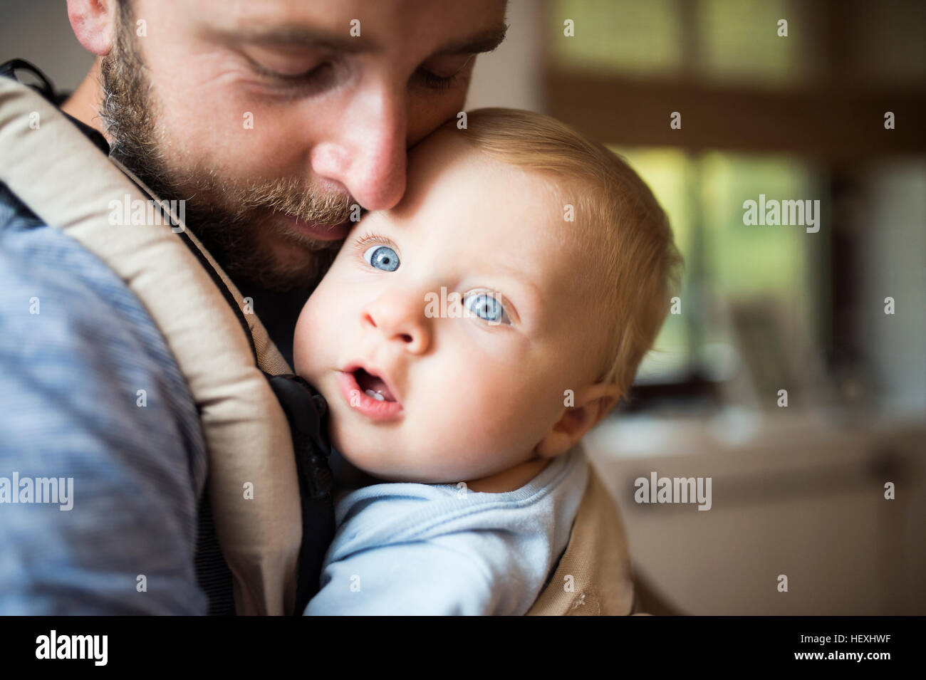 Father cuddling with baby in baby carrier Stock Photo - Alamy