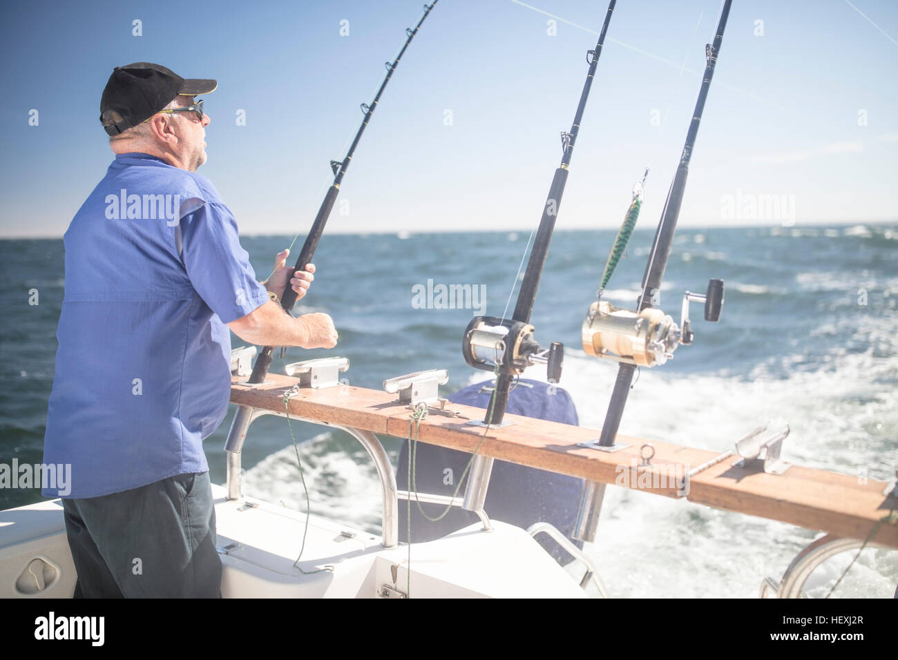 Man on boat deep sea fishing Stock Photo