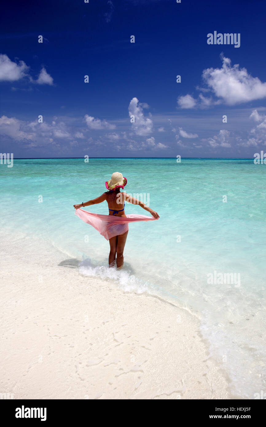 Maldives, woman standing in shallow water Stock Photo