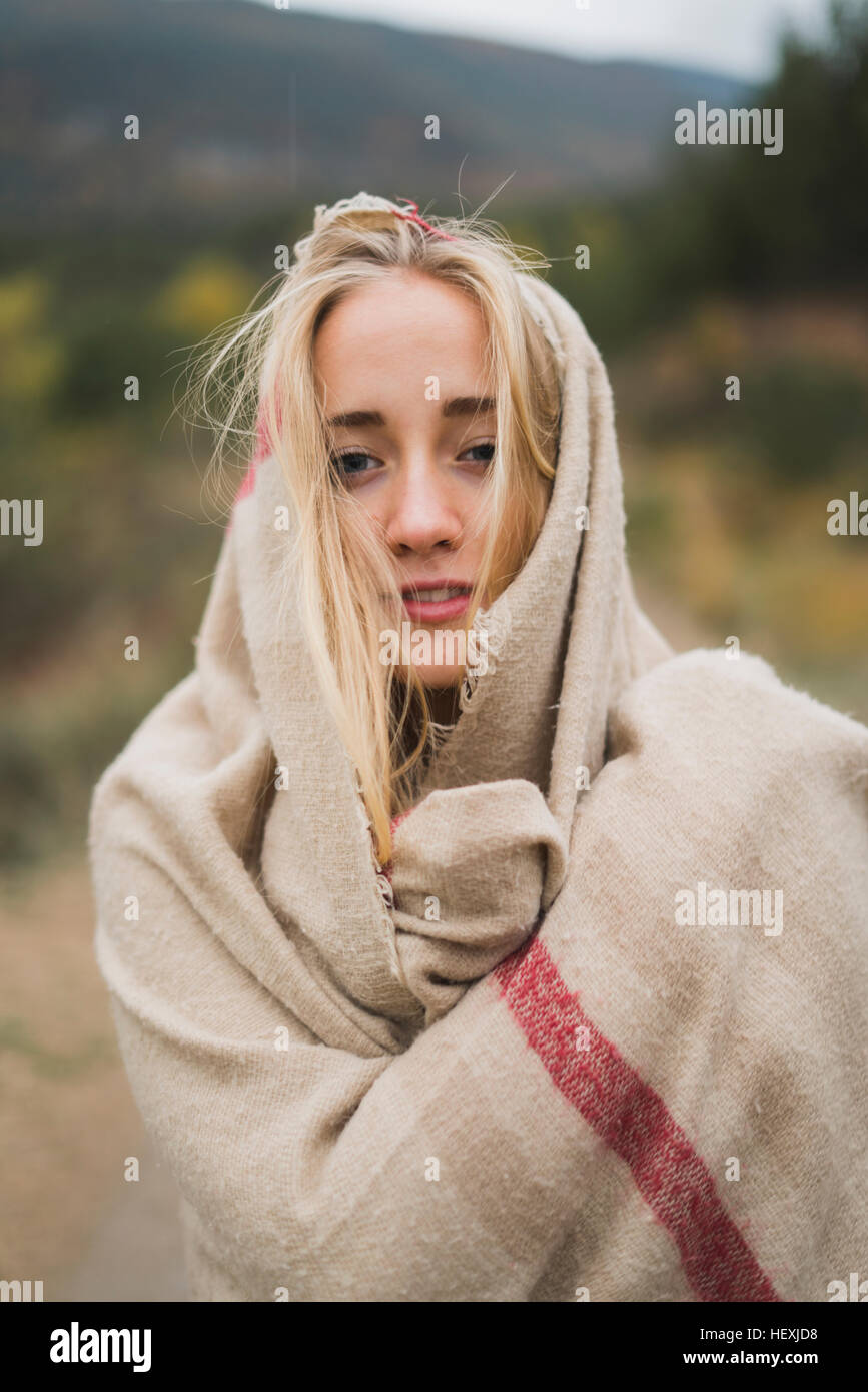 Portrait of young woman wrapped in a blanket outdoors Stock Photo - Alamy