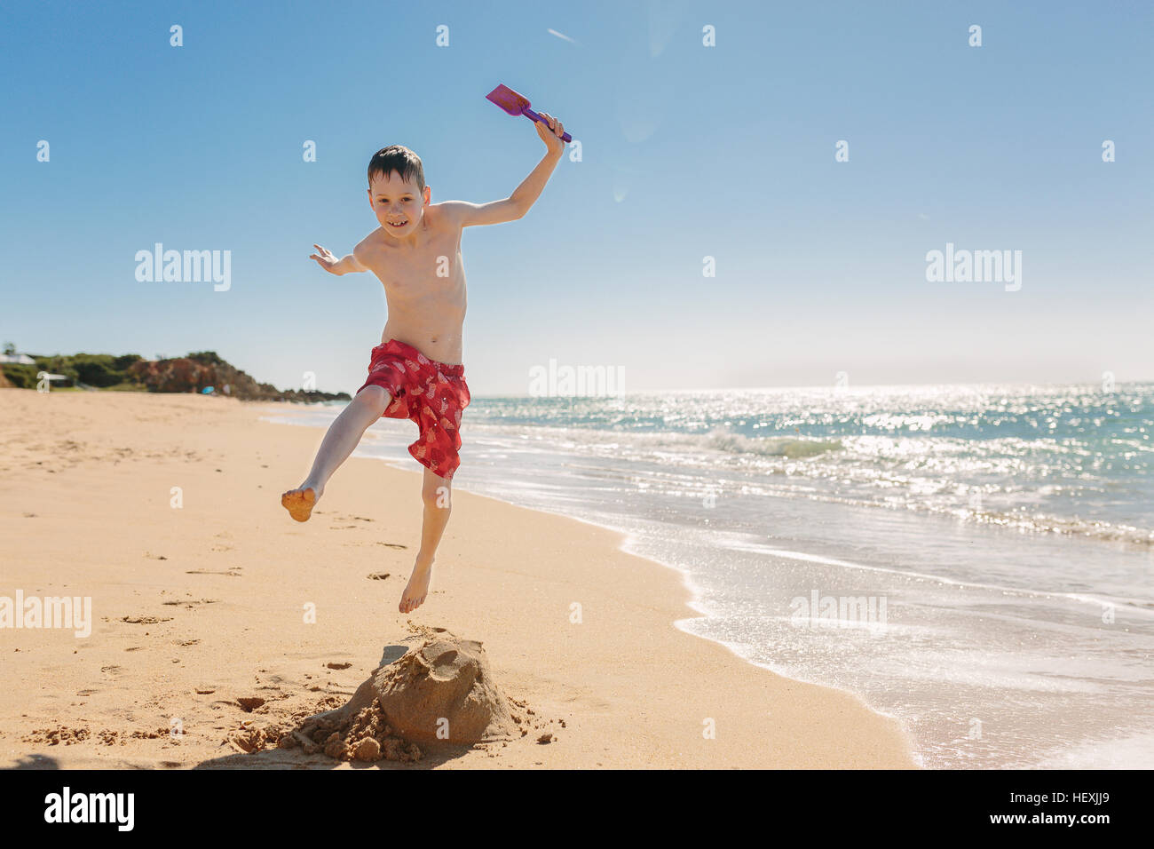 Boy playing and jumping on the beach Stock Photo