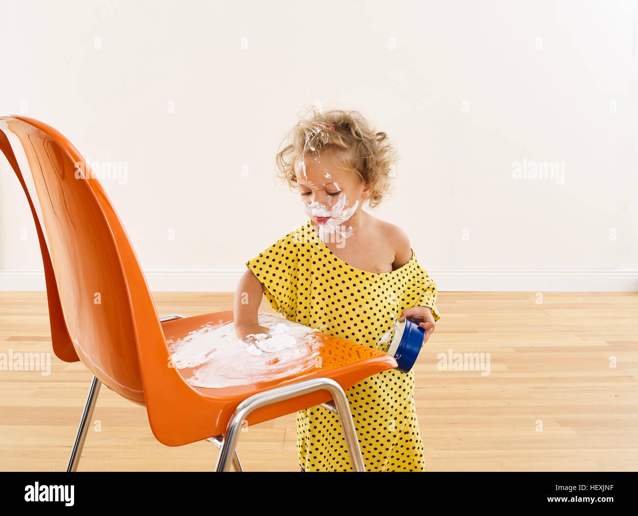 Little girl applying cream on chair Stock Photo Alamy