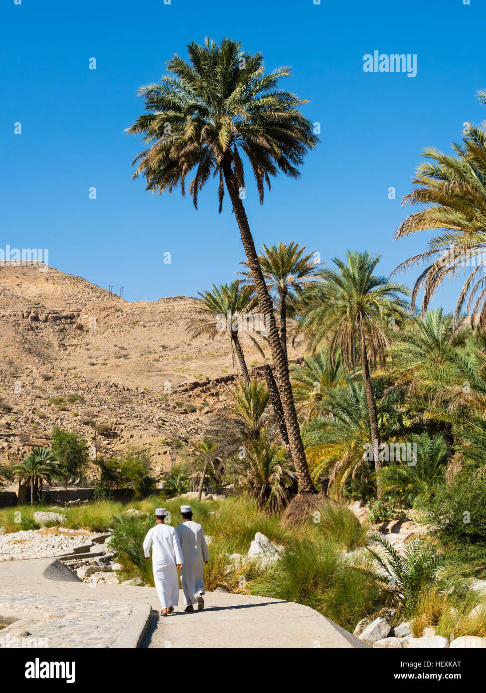 Oman, Sharqiyah, back view of two men on the way to Wadi Bani Khalid Stock Photo