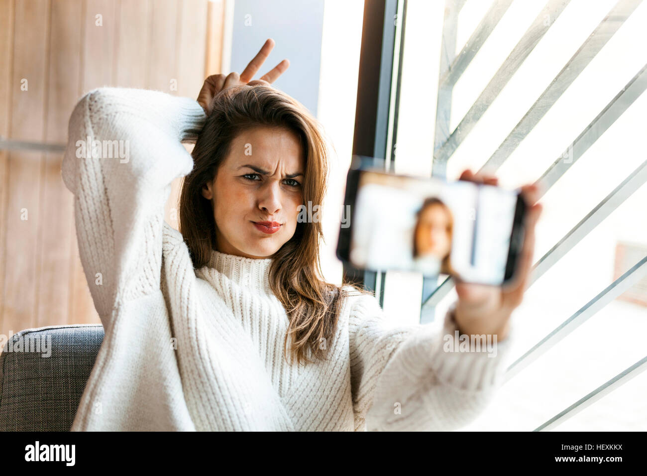 Playful young woman taking a selfie with cell phone Stock Photo - Alamy