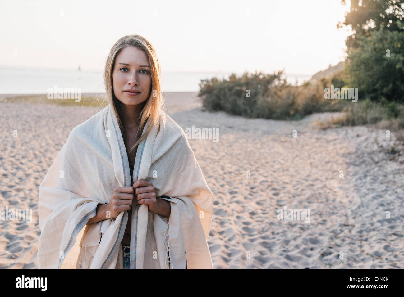 Portrait of young woman standing on the beach Stock Photo - Alamy