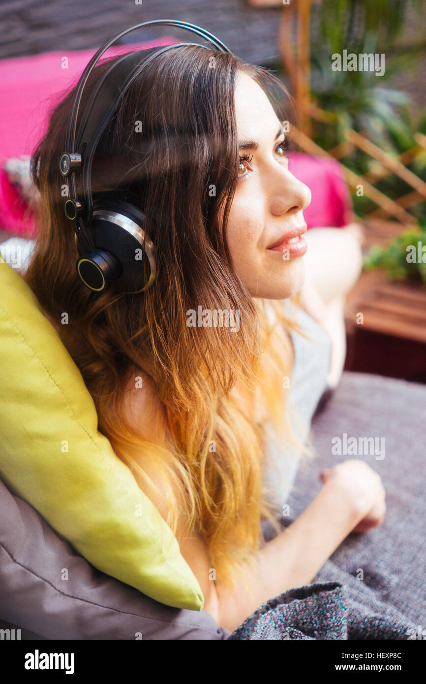 Young woman listening to music with headphones Stock Photo - Alamy