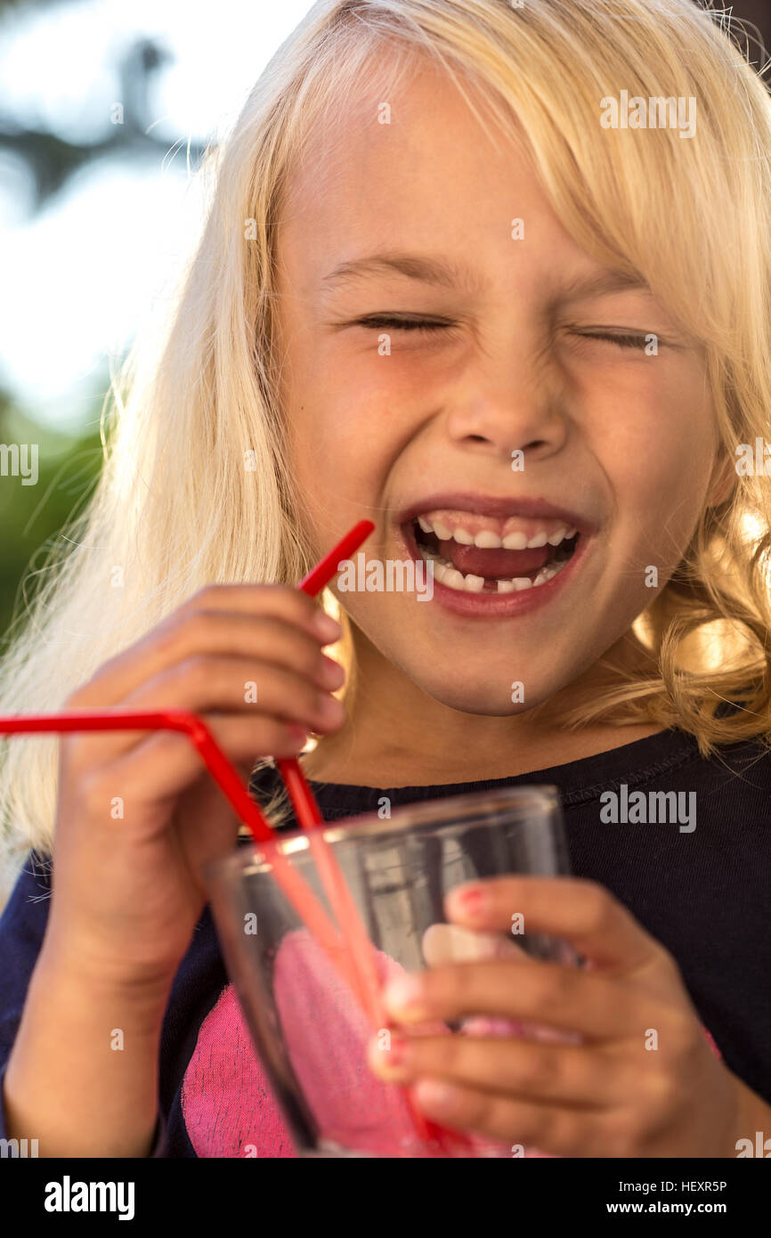 Laughing little girl drinking water with drinking straw Stock Photo Alamy