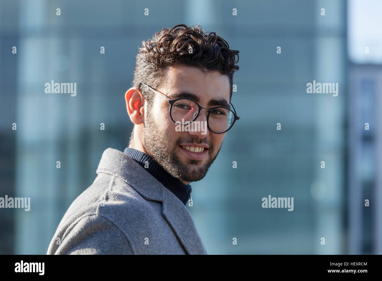 Portrait of smiling young businessman with beard and spectacles Stock Photo