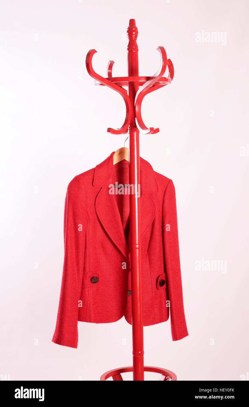 A ladies red jacket hanging on a coat stand Stock Photo