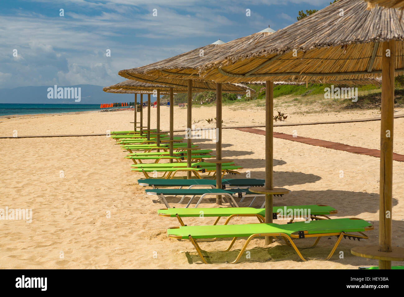 Sun loungers and parasols in a row on the sand at Skala Beach, Kefalonia, Greece Stock Photo