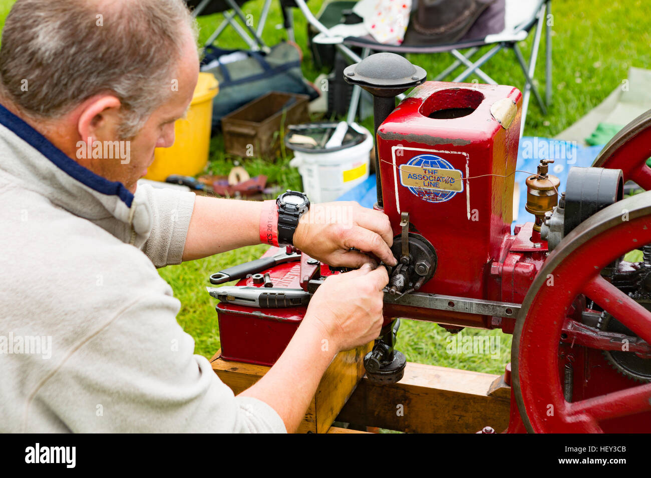 A man adjusts a Stationary Engine at a county show. Stock Photo