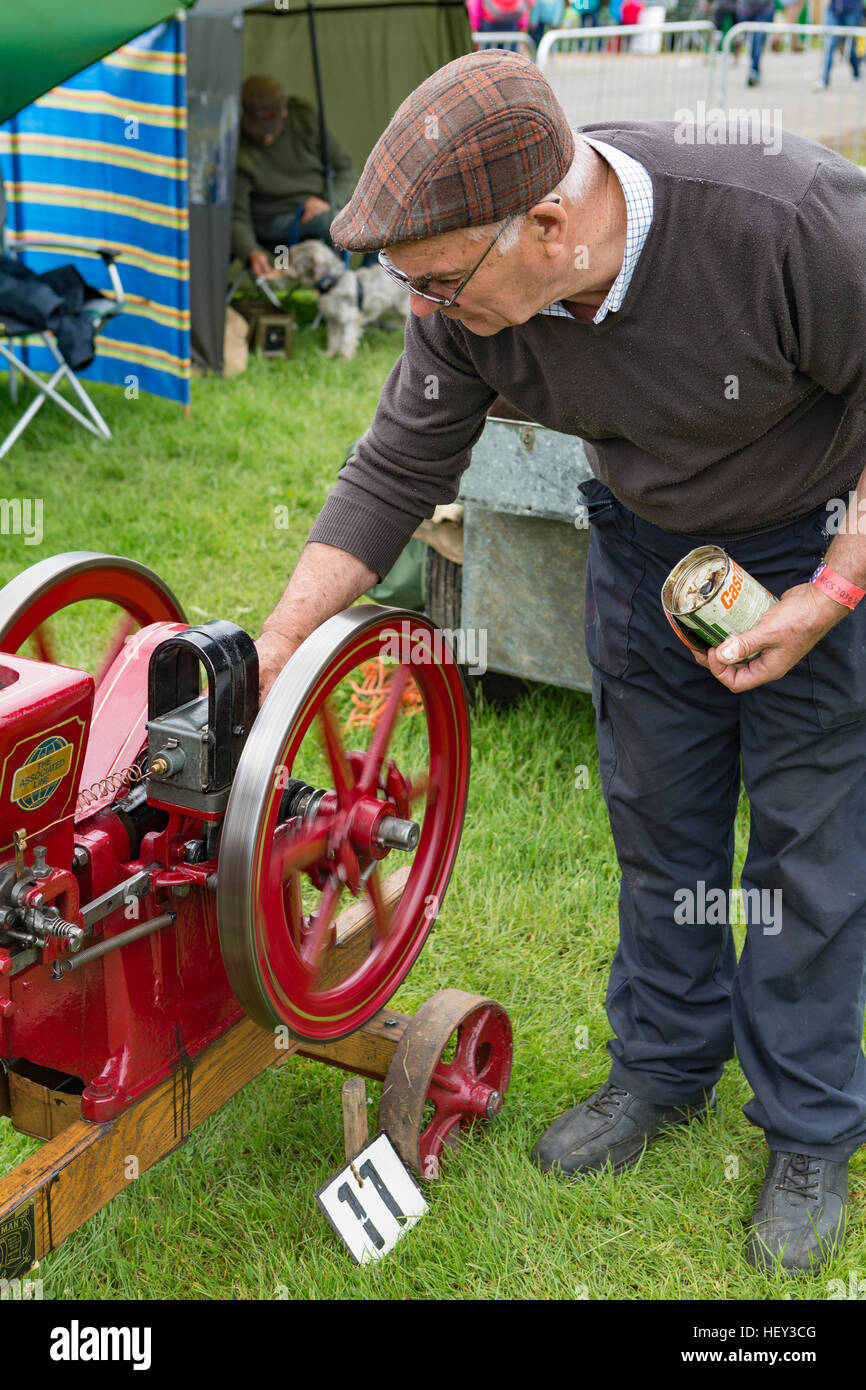 The ownser of a Stationary Engine Greases moving parts at a county show. Stock Photo