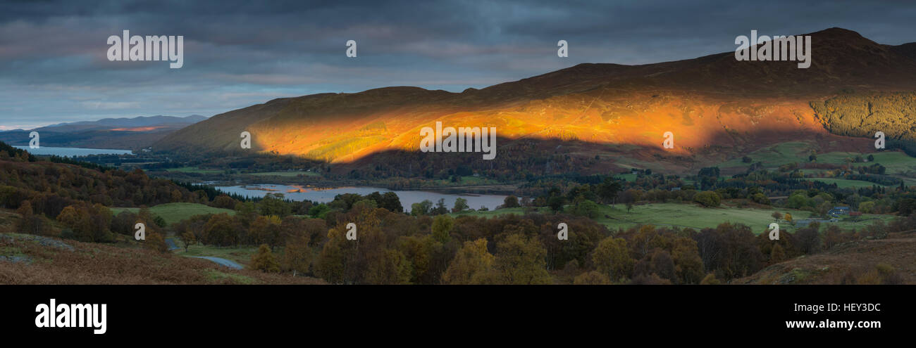 Beinn a' Chuallaich lit by the strong orange light of sunrise breaking through the clouds. Stock Photo