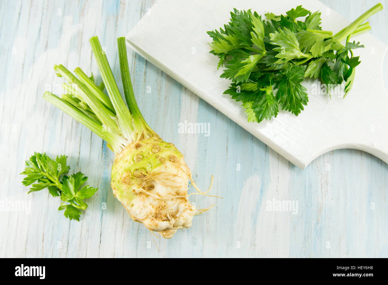 whole celery on a white cutting board on a blue table Stock Photo