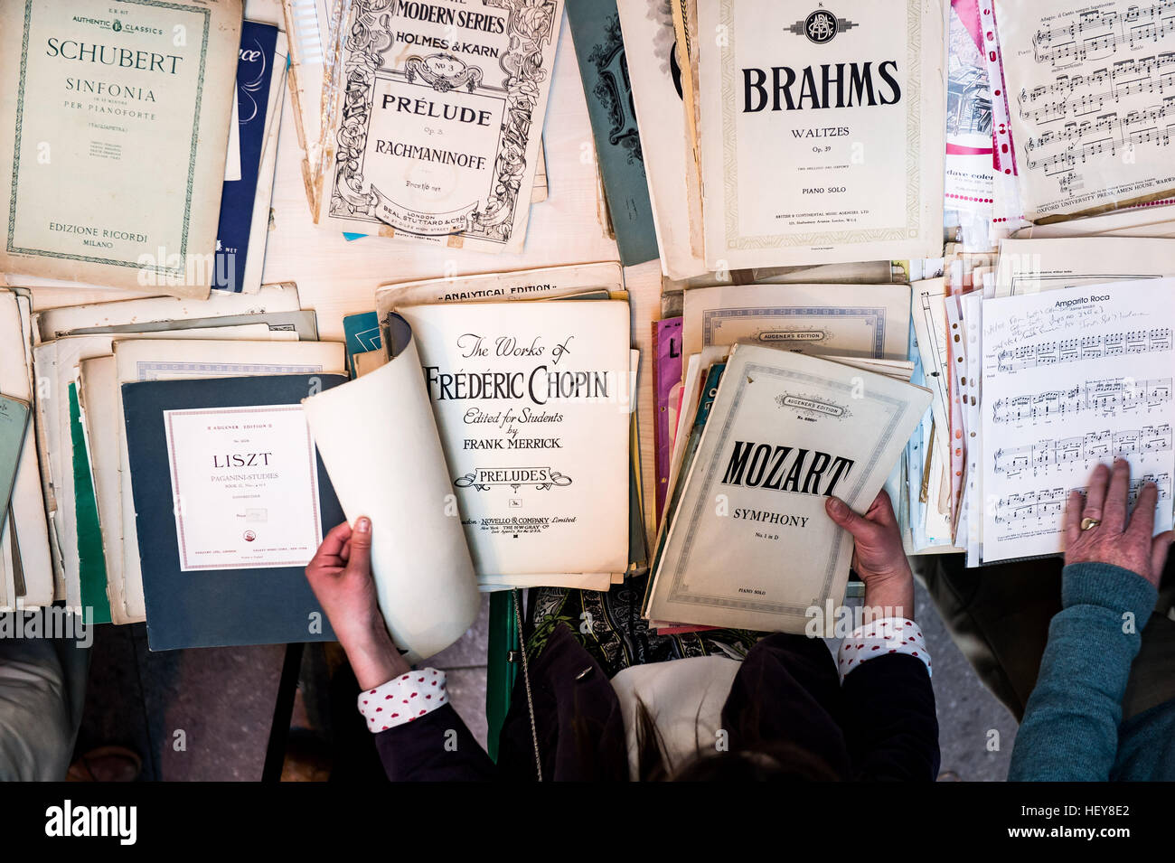 classic composers sheet music being looked over by hands of possible buyers Stock Photo