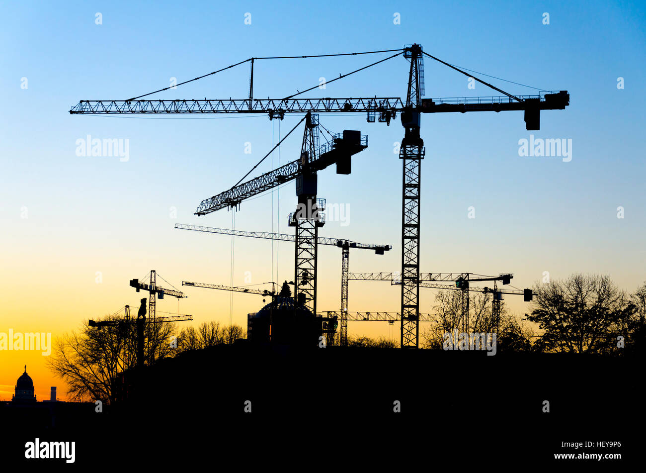 Silhouette of construction cranes in the evening over Berlin skyline, Germany Stock Photo