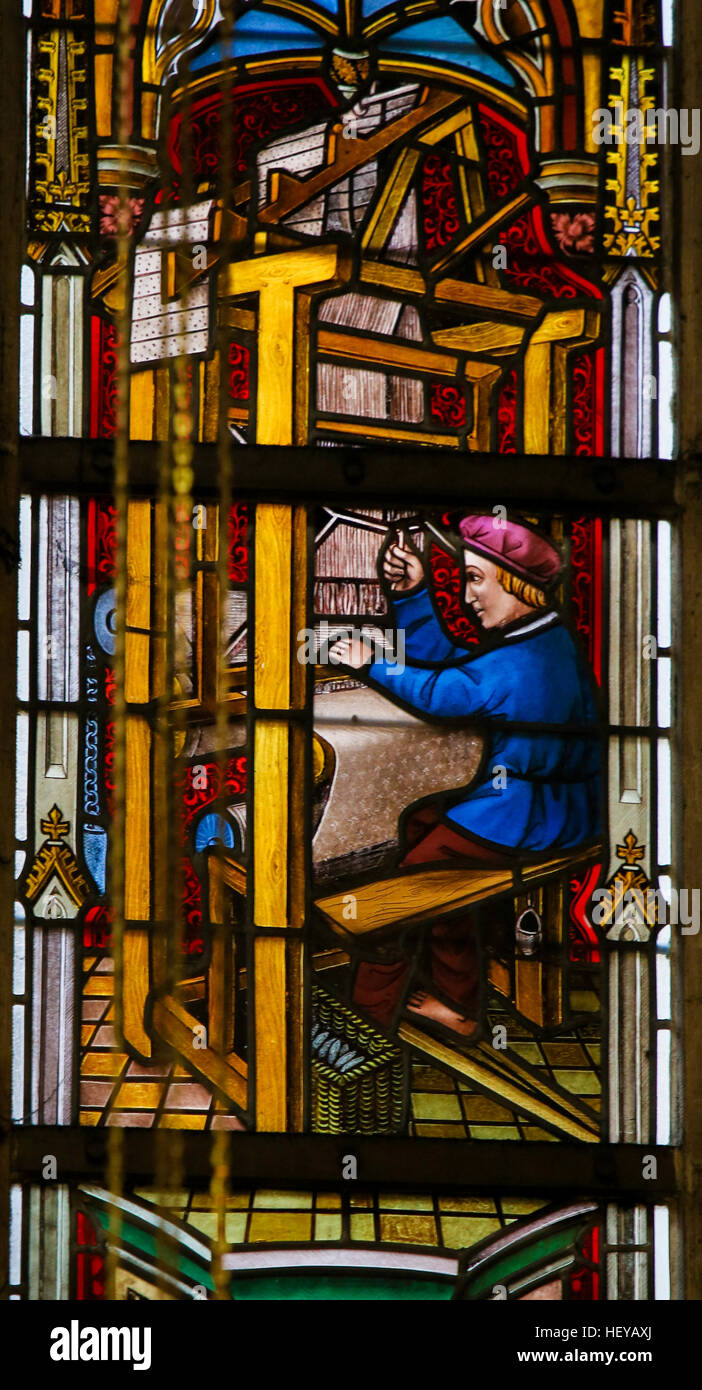 Stained Glass window depicting a man operatin a Weaving Machine, in the Cathedral of Saint Bavo in Ghent, Flanders, Belgium. Stock Photo