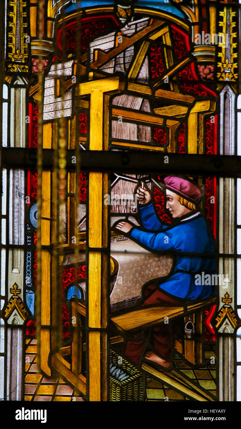 Stained Glass window depicting a man operating a Weaving Machine, in the Cathedral of Saint Bavo in Ghent, Flanders, Belgium. Stock Photo