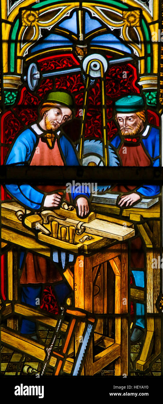 Stained Glass window depicting Carpenters at Work in the Cathedral of Saint Bavo in Ghent, Flanders, Belgium. Stock Photo