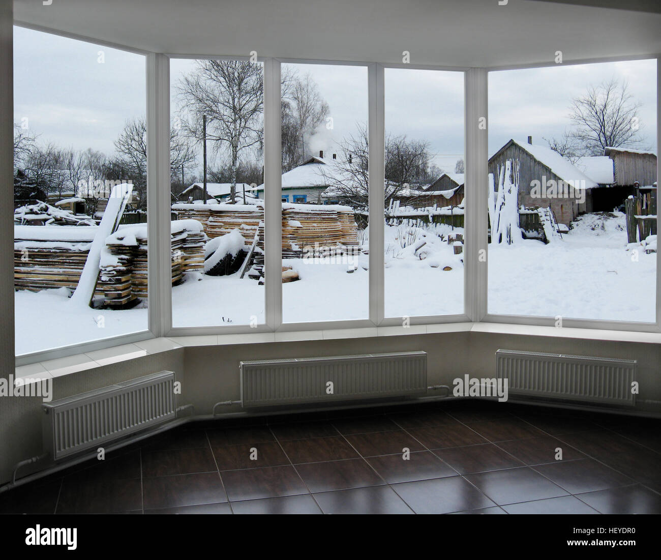wide window overlooking the winter rural landscape with house Stock Photo