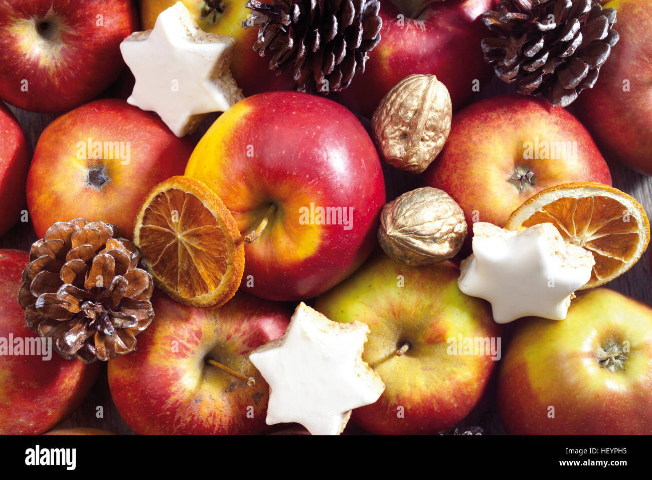 Christmas plate, format-filling: assortment of apples, walnuts, star-shaped cookies, candied oranges and pine cones Stock Photo