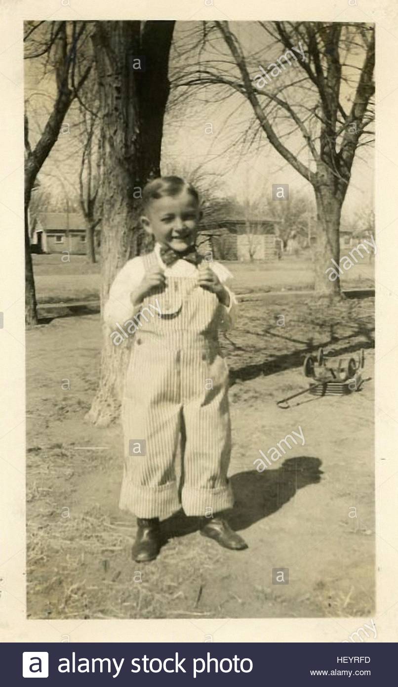 smiling little boy standing outside in the vintage photographs from