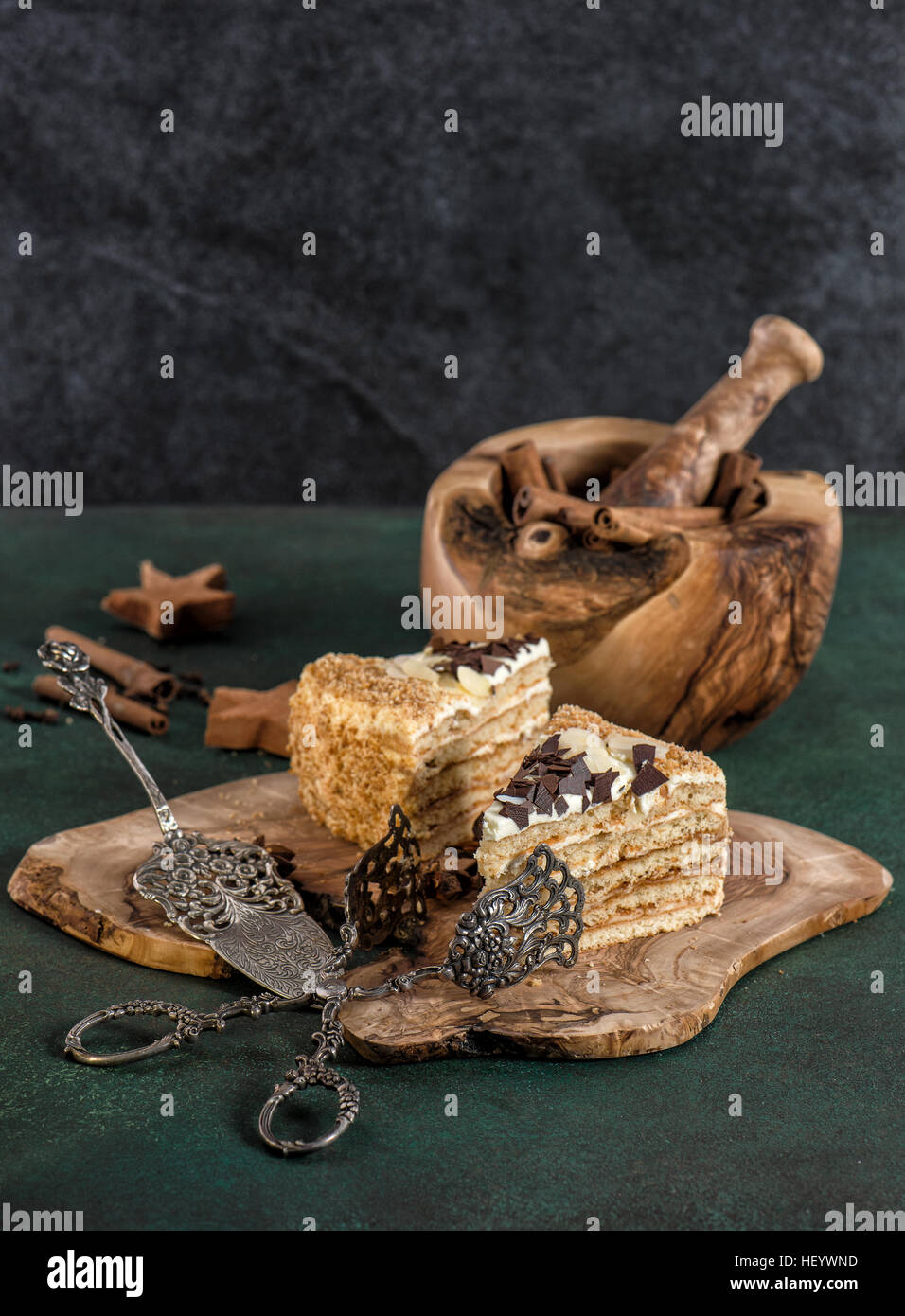 Honey cake with spices and vintage tools on dark background. Sweet food Stock Photo