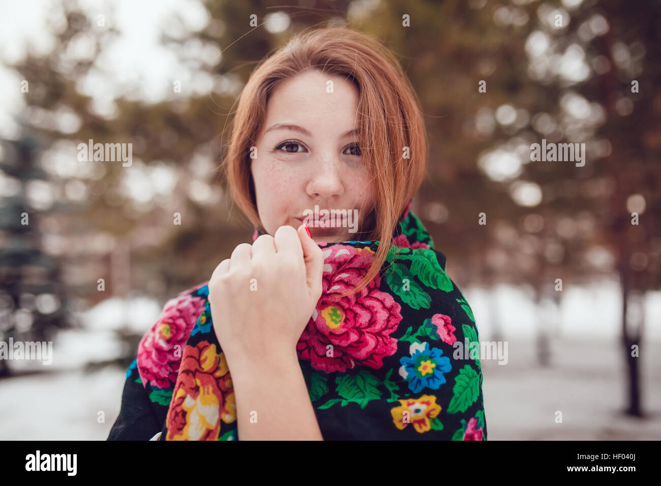 Russian beauty woman with red hair and freckles in the national scarf  stands on a background of trees Stock Photo - Alamy