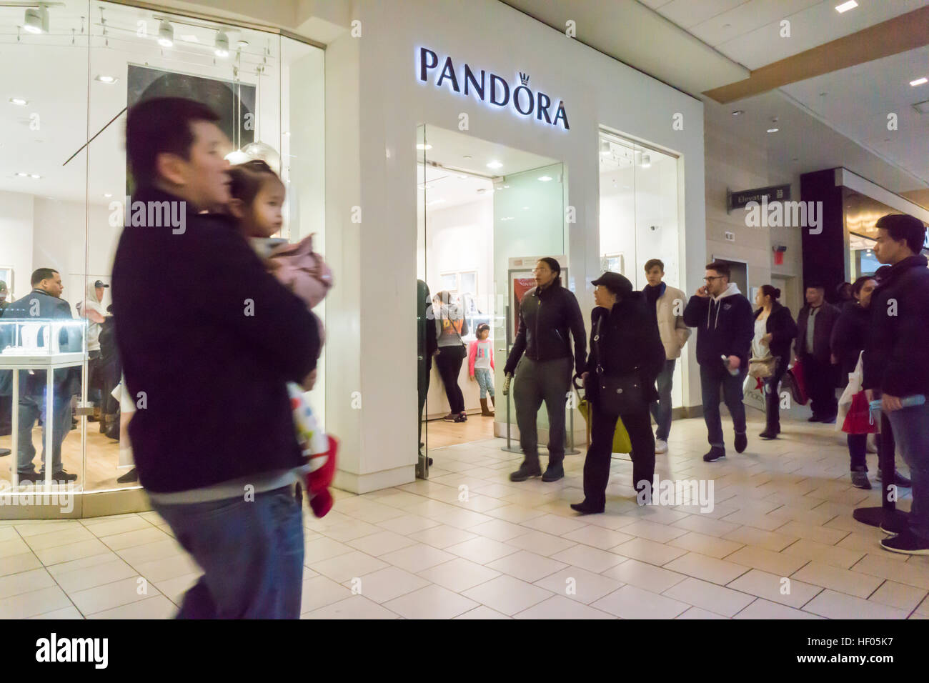 New York, USA. 24th Dec, 2016. Last minute shoppers pass the Pandora  jewelry store in the Queens Center Mall in the borough of Queens in New  York on Christmas Eve, Saturday, December