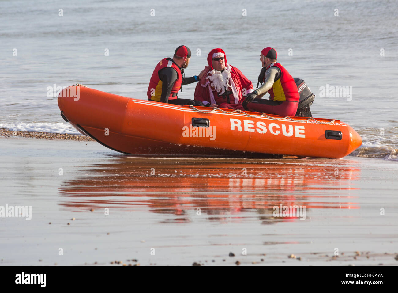 Durley Chine, Bournemouth, Dorset, UK. 26 December 2016. Bournemouth Lifeguard Corps rescue Father Christmas at Durley Chine beach on Boxing Day. The Corps, founded in 1965, is one of the largest and most successful volunteer lifeguard clubs in the UK with more than 100 members aged from 7 to 70. Credit: Carolyn Jenkins/Alamy Live News Stock Photo