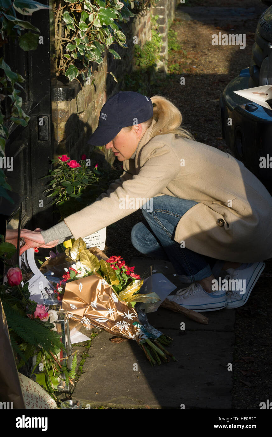 London, UK. 26th December, 2016. A fan laying flowers in memory of George Michael outside his London home, The Grove, Highgate, North London. The pop superstar has died at the age of 53 from suspected heart failure. Credit: Alex MacNaughton/Alamy Live News Stock Photo