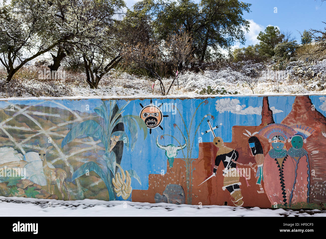 Snow covers desert plants behind a colorful southwestern themed mural on a wall at the town library in Oracle, Arizona, USA Stock Photo