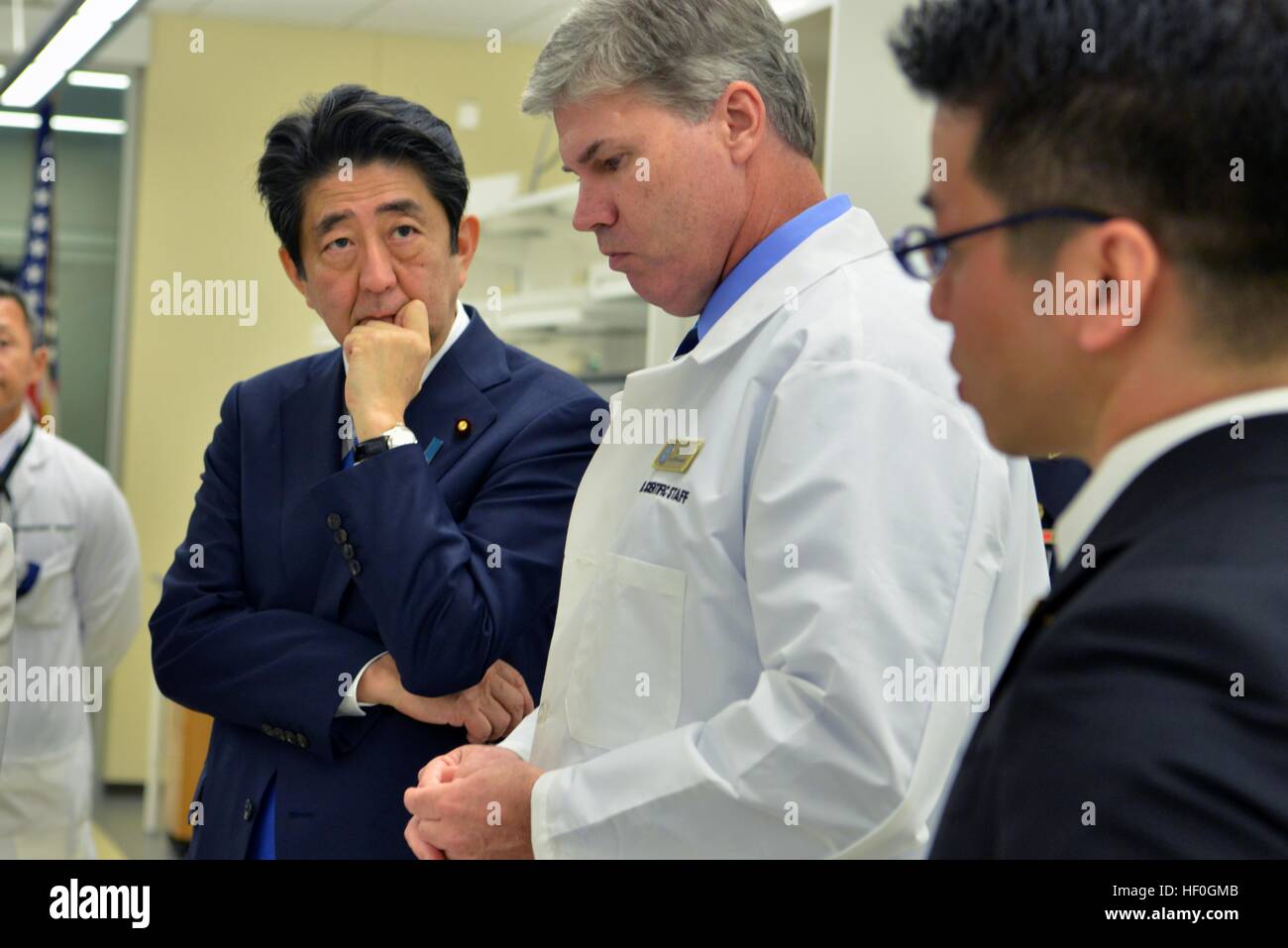 Japanese Prime Minister Shinzo Abe, left, is briefed by Dr. John Byrd during a tour of the laboratory at the Defense POW/MIA Accounting Agency facility December 26, 2016 in Pearl Harbor, Hawaii. Abe is the first Japanese leader to publicly view the site of the Pearl Harbor Attack. Stock Photo