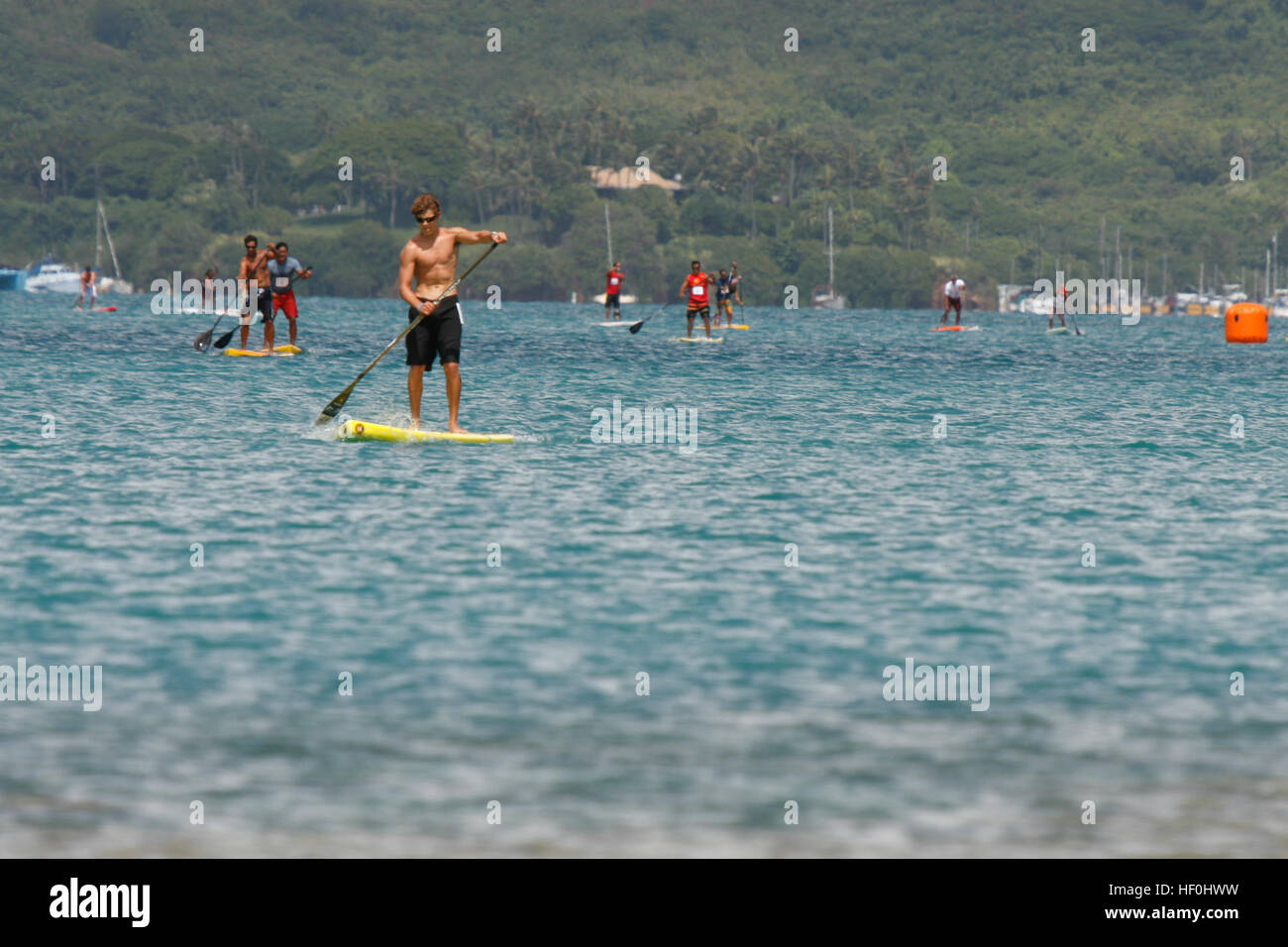 Stand up paddle boarders participate in Marine Corps Air Station Kaneohe Bay’s first stand up Paddling Race in Oahu’s Kaneohe Bay during Bayfest 2011, July 16. Forty-five military members, family members, and civilians participated in the four mile race near MCAS Kaneohe Bay’s shore. Bayfest 2011 110716-M-DX861-048 Stock Photo
