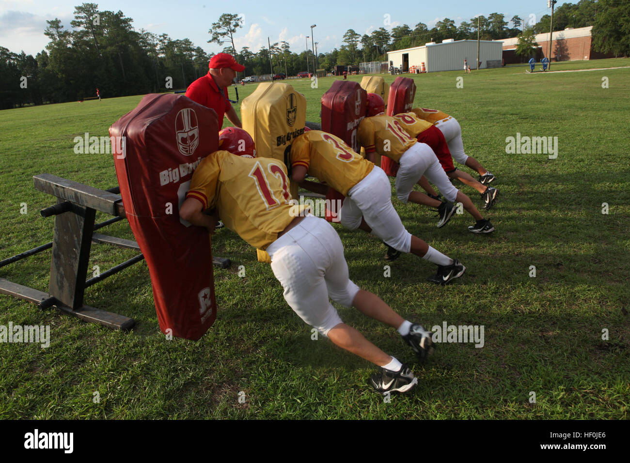 Lejeune High School assistant football coach Mike Gardner practices Big Bruiser drills with his football players, Aug. 10, during practice behind LHS aboard Marine Corps Base Camp Lejeune. The Lejeune High School football team has set high expectations for this season and plan on going above .500 for the first time in nearly six years. Lejeune High School Devil Pups football team sets high expectations 110817-M-TM193-001 Stock Photo