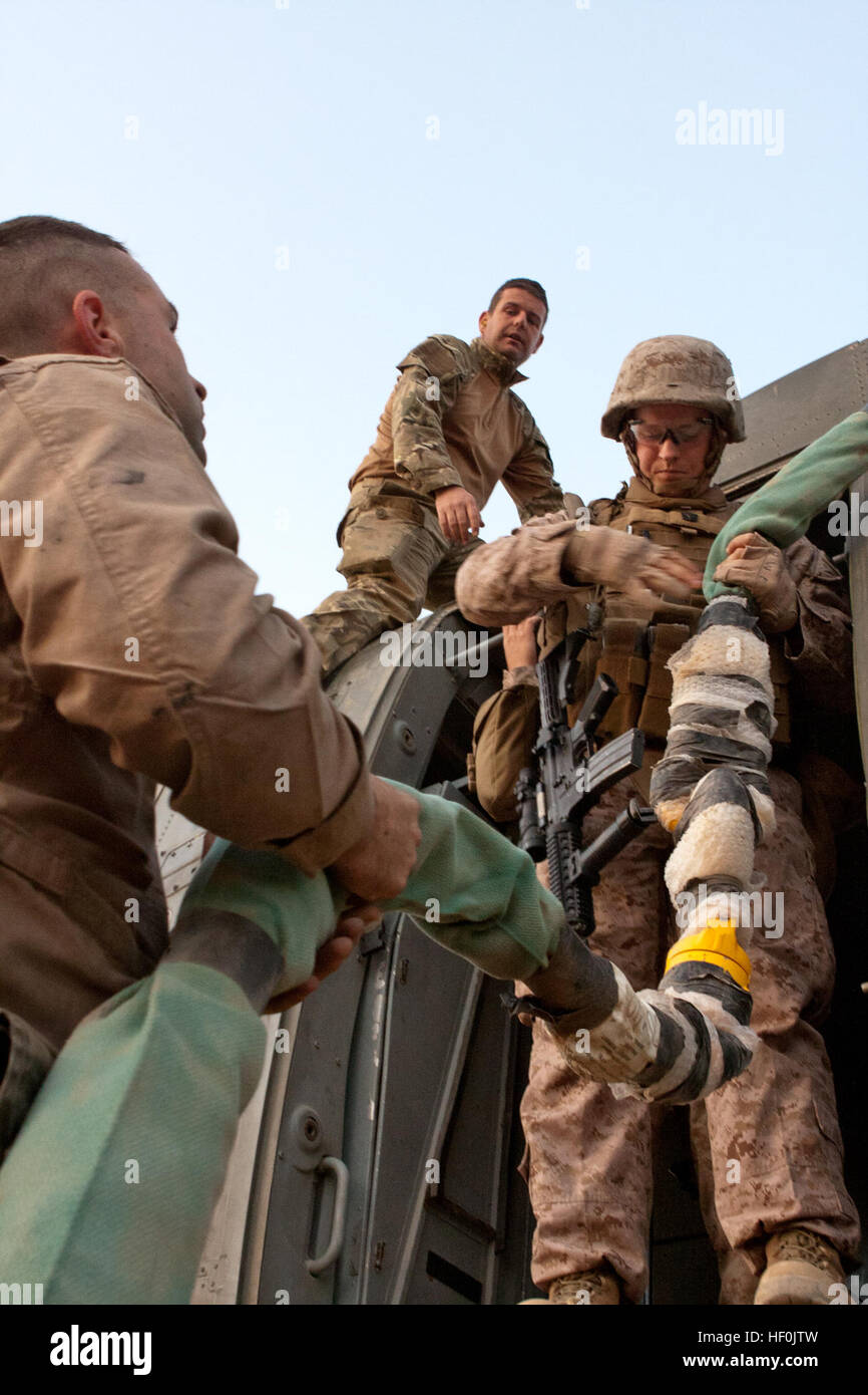 U.S. and U.K. service members load straps onto a British Royal Air Force Merlin HC3 helicopter for transport, undisclosed location, Helmand Province, Afghanistan, September 15, 2011. U.S. Marines of Marine Heavy Helicopter Squadron 464, 2D Marine Aircraft Wing (Forward) and Helicopter Support Team, 2D Marine Logistics Group (Forward), were on hand to aid British troops recover U.K. Armed Forces equipment in support of International Security Assistance Force. (U.S. Marine Corps photo by Lance Cpl. Robert R. Carrasco/Released). U.S. and U.K. service members load straps onto a British Royal Air F Stock Photo