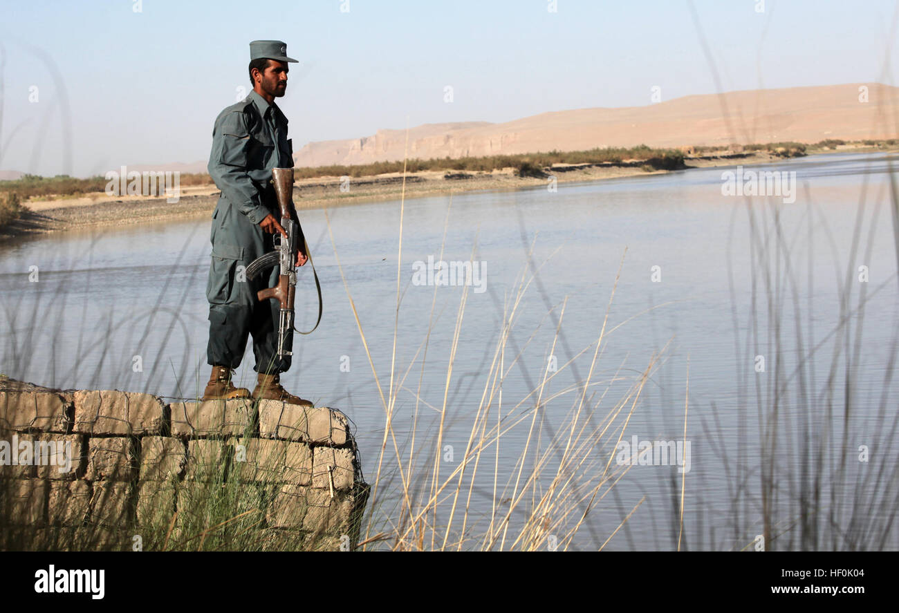 An Afghan Uniformed Police patrolman overlooks the Helmand River in Nawa district, Helmand province. This area of Nawa district has a complex water system of canals and streams, allowing for agriculture and greenery to grow throughout. Marines, Afghans enjoy pace of Nawa districtE28099s unique countryside 110920-M-YI942-018 Stock Photo