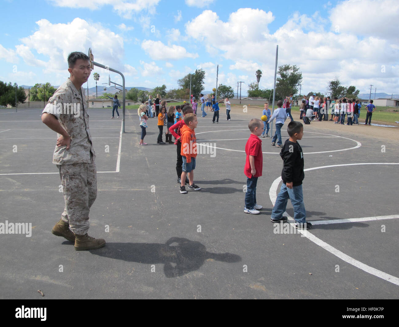 A Marine watches as students of Mary Fay Elementary School at Camp