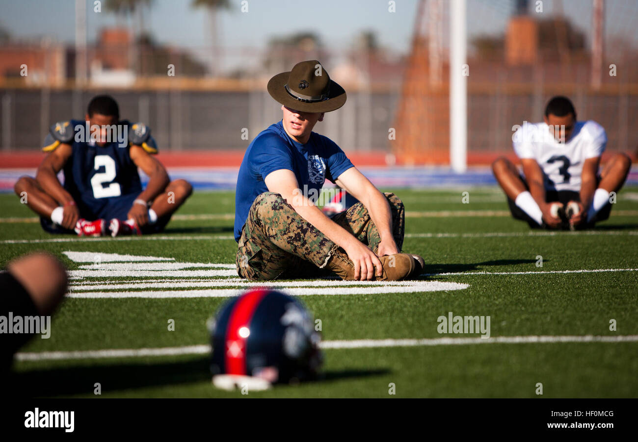 U.S. Marine Corps Sgt. Theodore Steber, center, a drill instructor assigned to Marine Corps Recruit Depot San Diego, leads a group of high school football players in stretching exercises before practice in Phoenix, Ariz., Jan. 1, 2012. The students were in Phoenix to participate in the inaugural Semper Fidelis All-American Bowl. DoD photo by Sgt. Mark Fayloga, U.S. Marine Corps (Released) 120101-M-YO938-016 (6641606175) Stock Photo