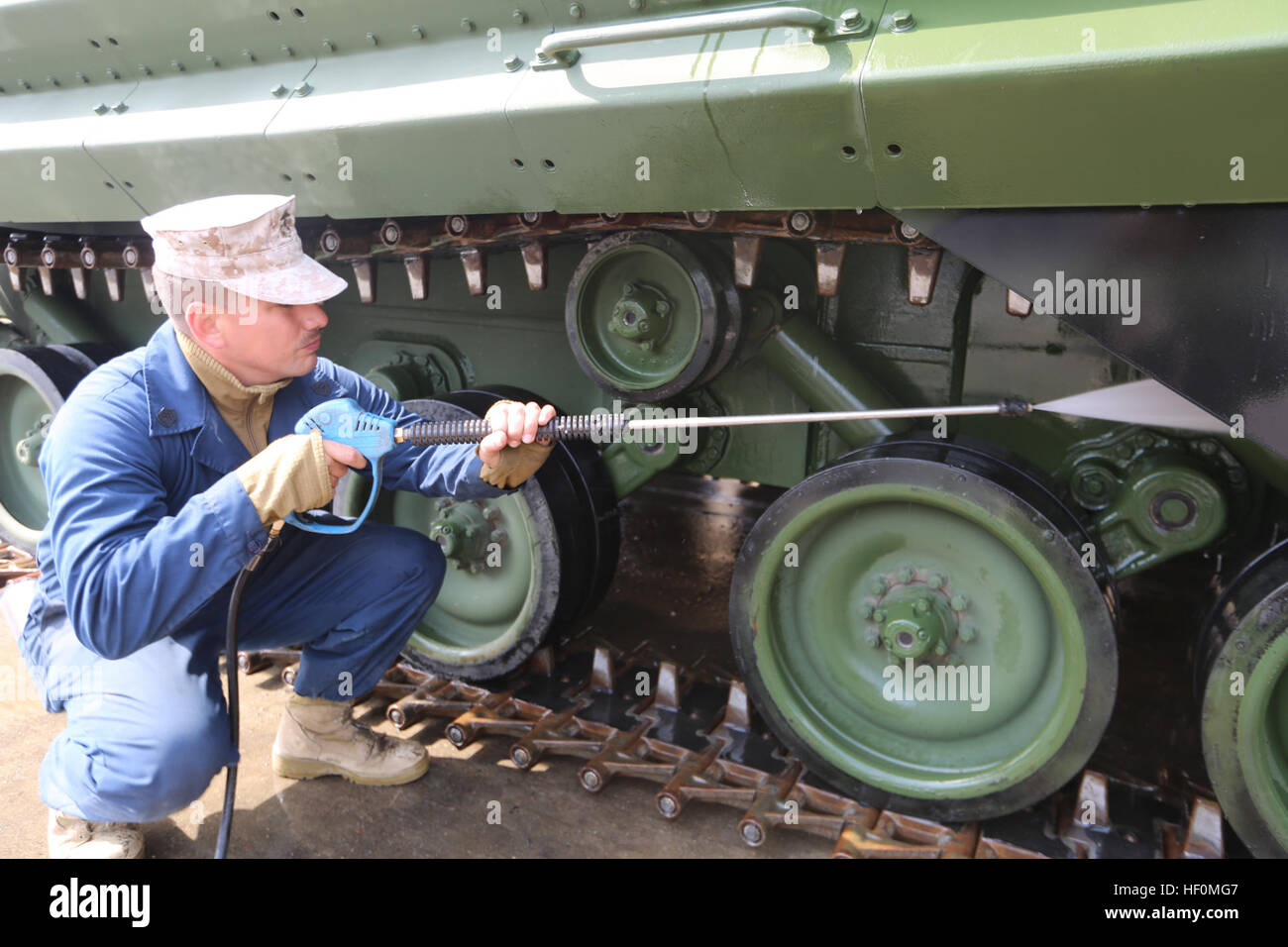 U.S. Marine Gunnery Sgt. Alberto S. Moreno pressure washes the tracks of an M-88 Hercules recovery vehicle at the Gwangyang Port, Republic of Korea Apr. 7 during exercise Freedom Banner 2014. During the wash down process the Marines cleaned excess dirt, sand, and foreign contaminants that were caked on the equipment as a result of their use in amphibious assault exercise Ssang Yong 14. Once the vehicles were cleaned they were staged in a holding lot awaiting final agricultural inspections before the final black load of gear onto the USNS 2nd Lt. John P. Bobo. Moreno is a platoon Sgt. with 3rd  Stock Photo