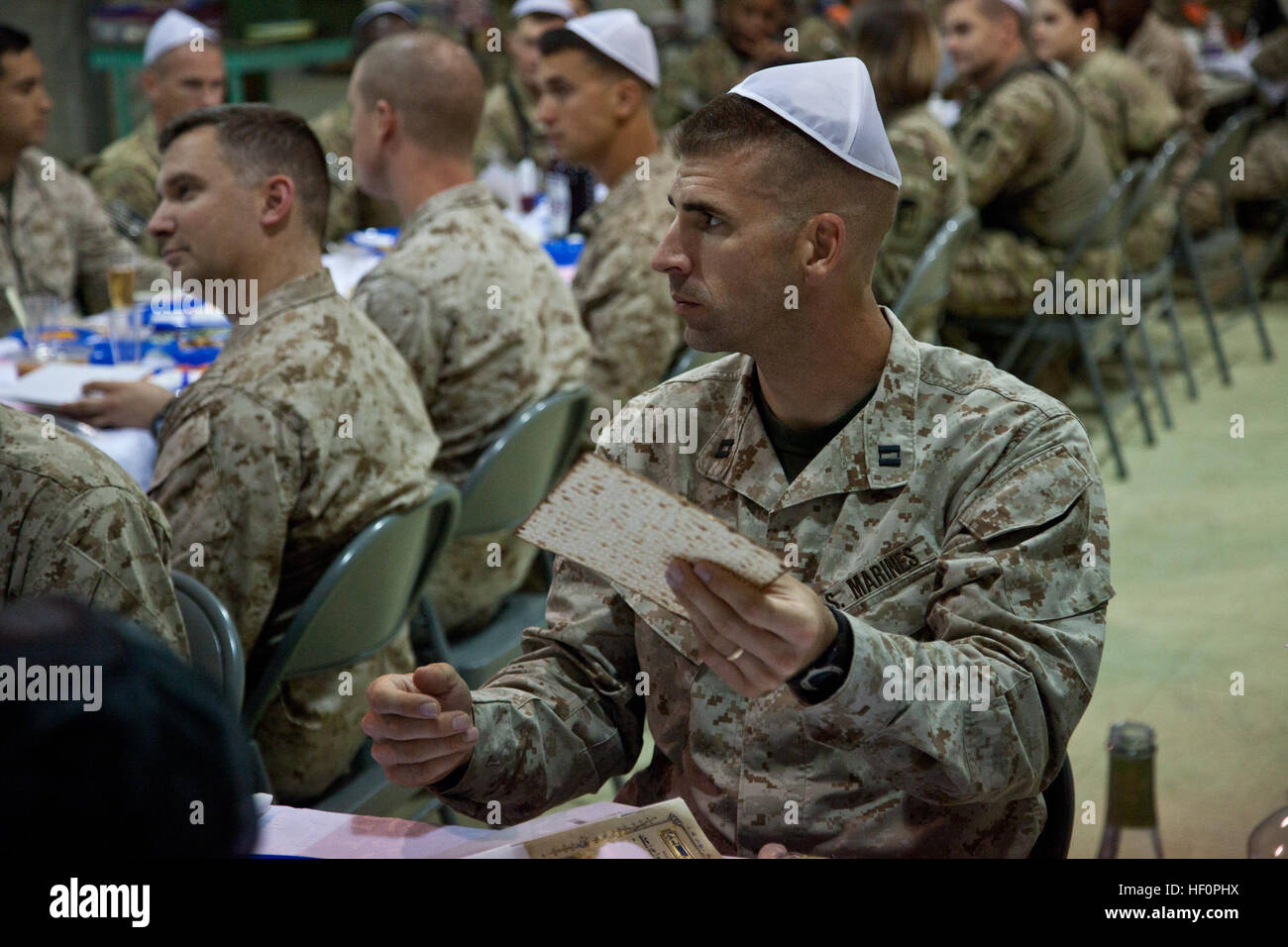 U.S. Marine Capt. Daniel Hinkson, Combat Logistics Battalion 1, holds a piece of Matzah bread during a Passover Seder here, April 7, 2012. Passover commemorates the story of the Exodus, in which the ancient Israelites were freed from slavery in Egypt. The meal was one of the various religious celebrations observed by service members aboard Camp Dwyer over the weekend. US service members celebrate Easter, Passover aboard Camp Dwyer 120407-M-PH863-354 Stock Photo