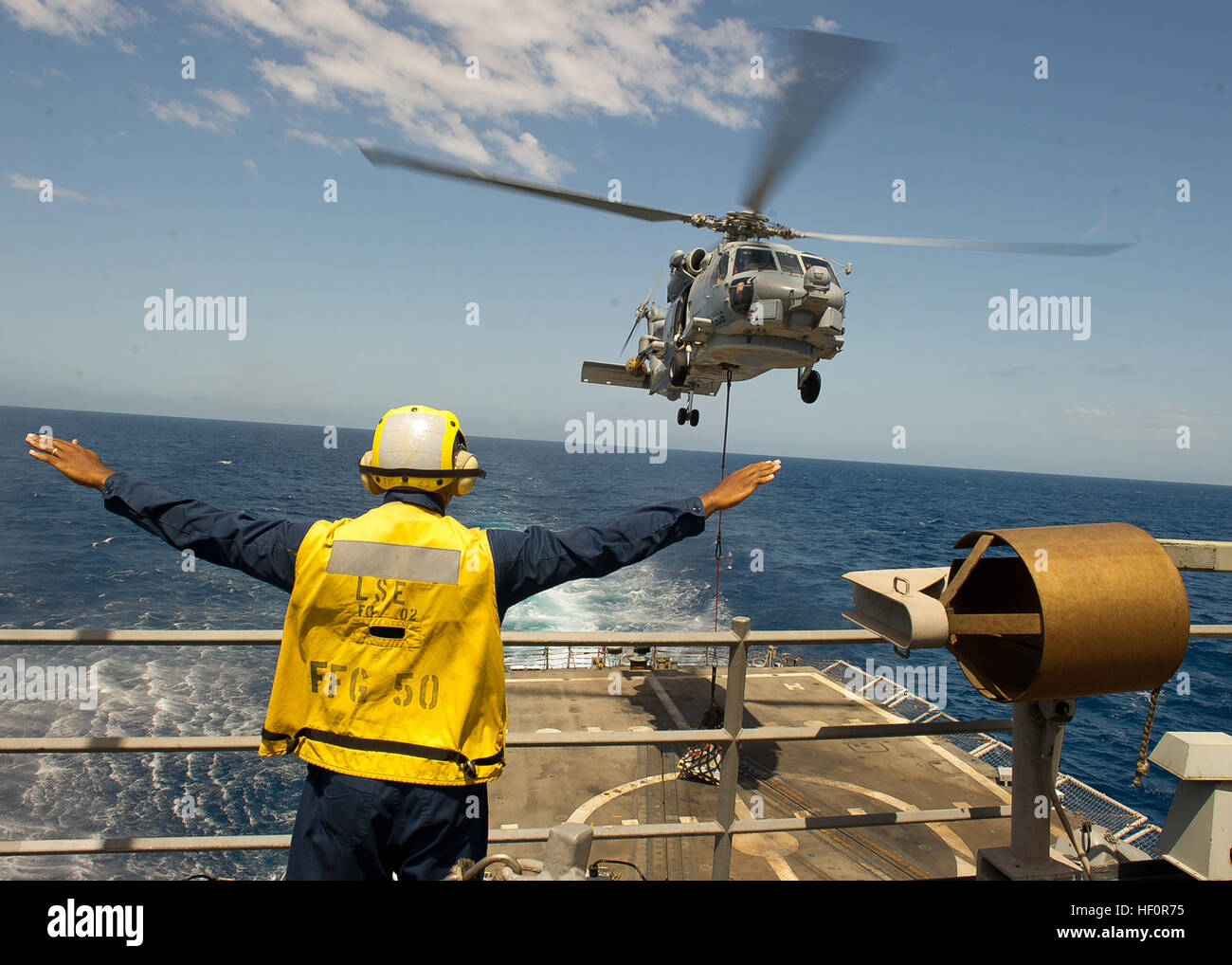 Boatswain’s Mate 3rd Class O’Bryant directs an SH-60B Seahawk, assigned to the “Vipers” of Helicopter Anti-Submarine Squadron Light 48, Det. 9, as it delivers supplies to guided-missile frigate USS Taylor (FFG-50). Taylor is assigned to commander, NATO Task Force 508 supporting Operation Ocean Shield, maritime interception operations and counter-piracy missions in the U.S. 5th Fleet area of responsibility. Flickr - DVIDSHUB - USS Taylor replenishment at sea (Image 4 of 9) Stock Photo