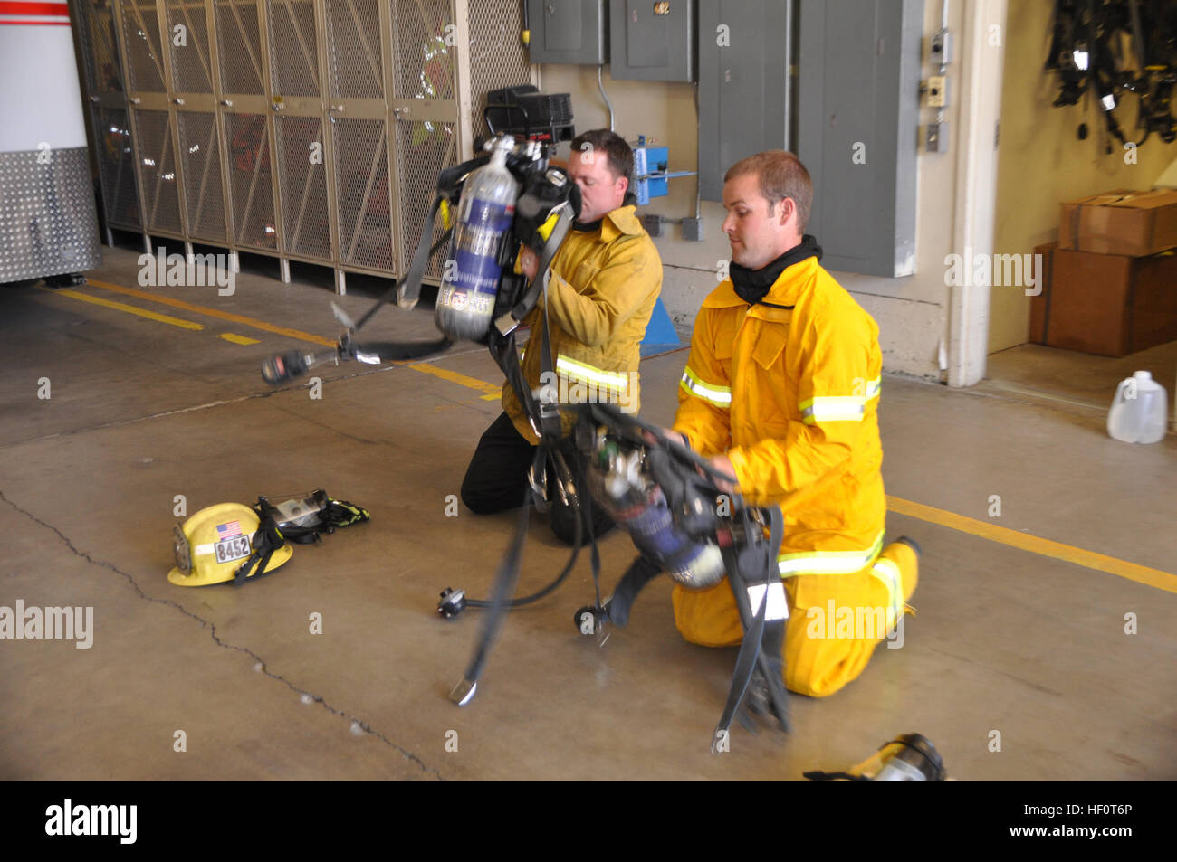 Agent Jeff Swearingen (right) with the Criminal Investigation Division of the Police Department aboard Marine Corps Logistics Base Barstow and Fire Prevention Officer Gaberiel Hammett, with the Fire Department aboard MCLB Barstow, don their self-contained breathing aparatus during a cross-training session at the main fire station aboard the base May 9. Swearingen is an arson investigator with the  of the police department learning about fire operations with the aim of becoming a more effective arson investigator. Marine Corps police cross-train with base fire department in arson investigation  Stock Photo