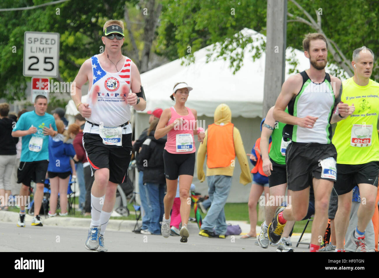 Aaron Wolf, the North Dakota National Guard family readiness support assistant, runs the Fargo Marathon, May 19, Fargo, N.D. He was running in honor of U.S. Army Spc. Keenan Cooper on the Tragedy Assistance Program for Survivors (TAPS) Run and Remember Team. Marathoners fight through a number of difficulties over the course of a 26.2-mile race, from losing toenails to bleeding from fabric chafing. The TAPS team is running in the Fargo Marathon events in memory of military service members who died while in service to the United States military, and also to raise money for the TAPS programs that Stock Photo