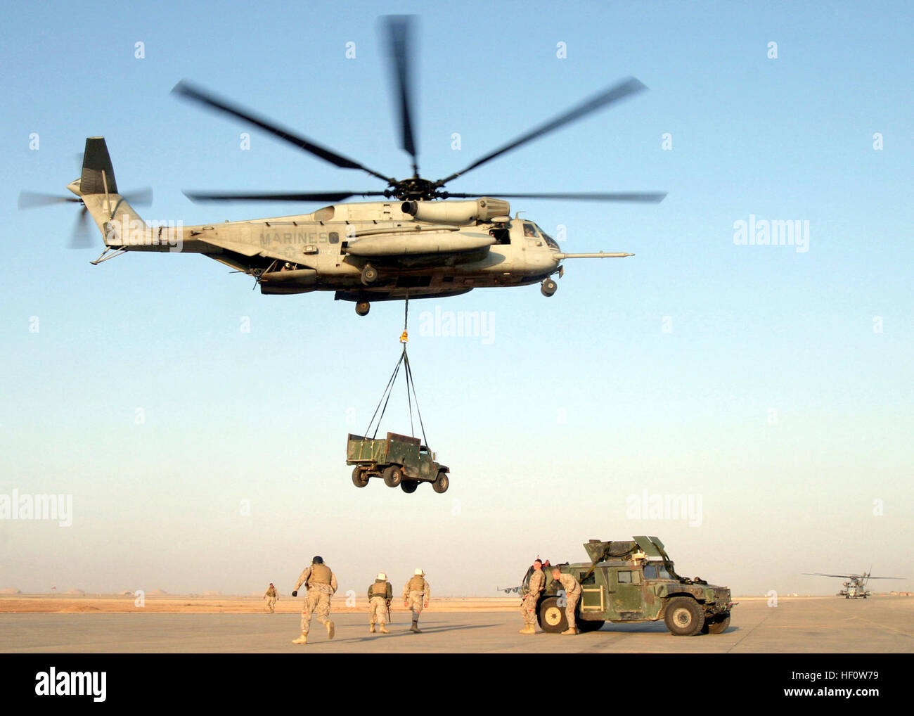 A US Marine Corps (USMC) CH-53E Super Stallion, 2nd Marine Aircraft Wing (MAW), lifts a flank armored High-Mobility Multipurpose Wheeled Vehicle (HMMWV) from the flightline of Al Asad Air Base (AB), Iraq, for delivery to infantry units inserted at a forward location for Operation RIVER SWEEP in support of Operation IRAQI FREEDOM. Marine CH-53E Super Stallion (2164964162) Stock Photo