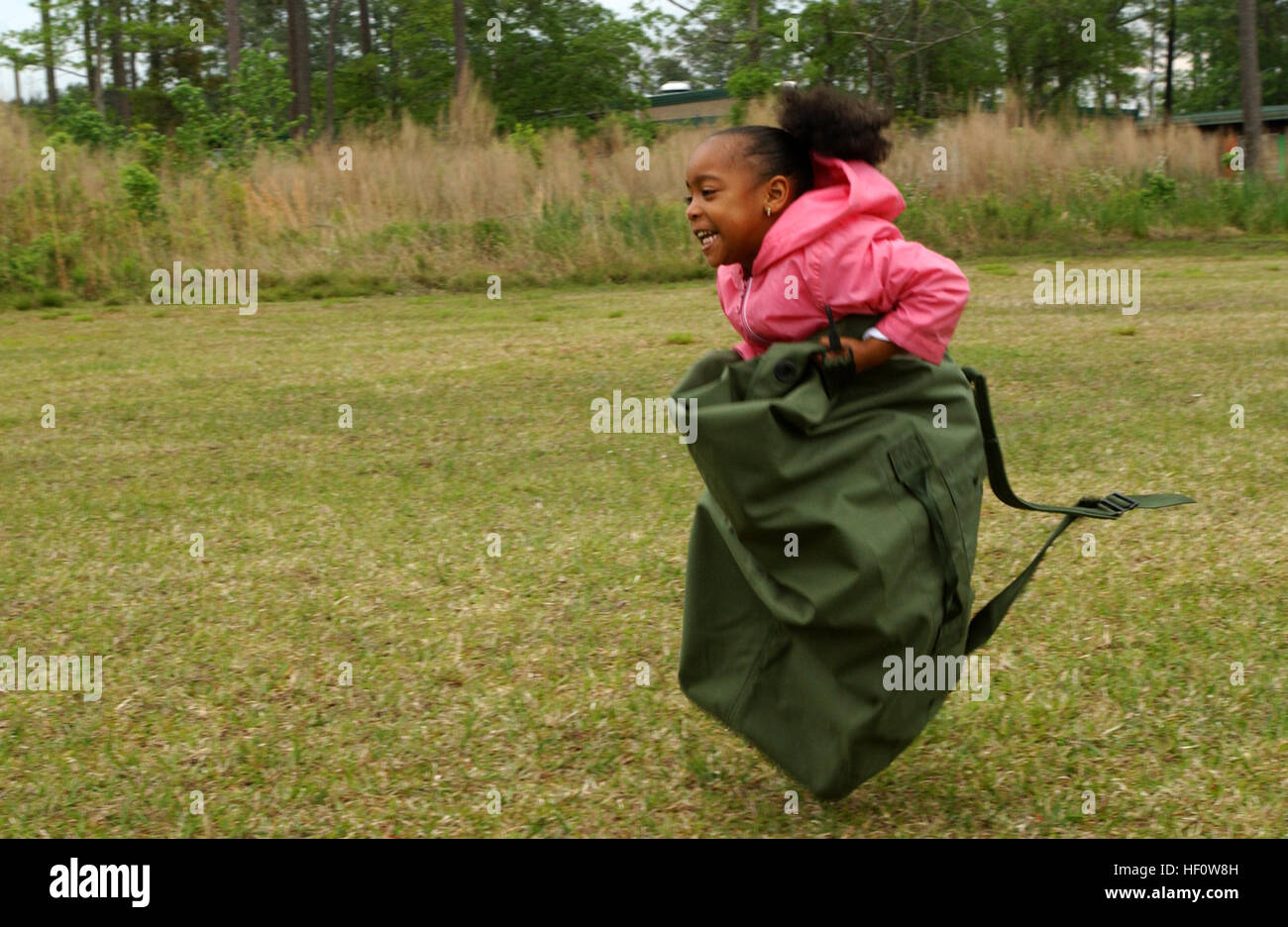 050504-M-1188A-003 CAMP LEJEUNE, N.C. (May 4, 2005) — Tamia Covington, 5, races down the field during the sea bag race here May 4. More than 15 Marines with Headquarters and Service Battalion, 2nd Supply Battalion, 2nd Force Service Support Group, introduced various Marine Corps issued gear to students at the Tarawa Terrace 1 Primary School. (U.S. Marine Corps Photo by Lance Cpl. Joel Abshier)(Released) USMC-050504-M-1188A-003 Stock Photo