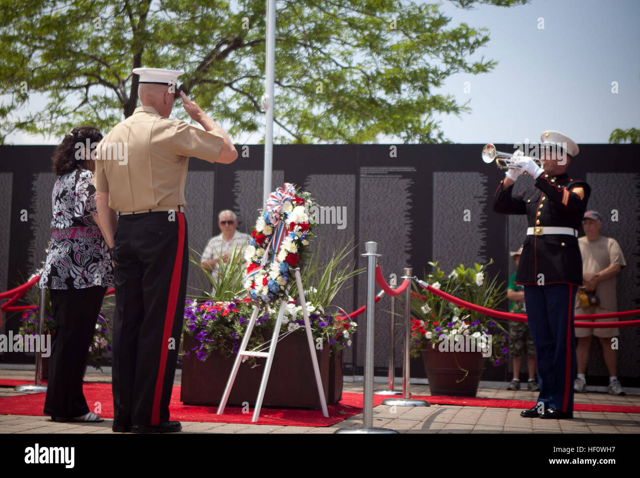 Lt. Gen. Steven A. Hummer, commander of Marine Forces Reserve and Marine Forces North, and Sandra Mandez-Ruiz, a Gold Star family member, listen to the playing of taps at a wreath laying ceremony at traveling Vietnam War Memorial Wall at Voinovich Park here June 12. Voinovich Park is one of the sites of displays available for public during the Marine Week Cleveland. Along with the wall, Marine Corps vehicles, aircraft and equipment will be available for viewing at Public Square, Voinovich Park, Gateway Plaza and Rock and Roll Hall of Fame. Marine Week Cleveland celebrates community, country an Stock Photo