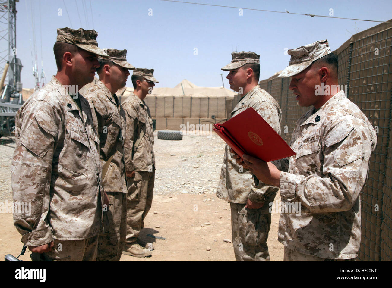 U.S. Marine Corps 1st Sgt. Roberto Alviso, front right, with Fox Company, 2nd Battalion, 5th Marine Regiment, Regimental Combat Team 6, reads a Navy and Marine Corps Achievement Medal award certificate on Forward Operating Base Shir Ghazay, Helmand province, Afghanistan July 28, 2012. The award was presented to Sgt. Brain Clark for the superior performance of his duties while serving as a Police Sergeant. (U.S. Marine Corps photo by Lance Cpl. Ismael E. Ortega/ Released) Awards ceremony on FOB Shir Ghazay 120728-M-RD023-008 Stock Photo